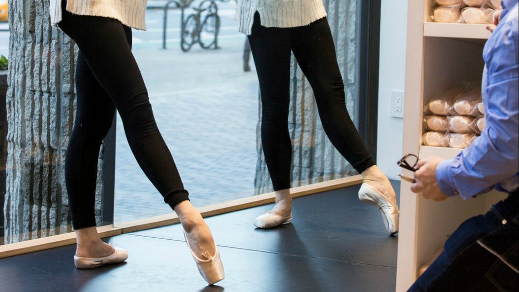 Two dancers being fitted for pointe shoes in store by a professional BLOCH fitter